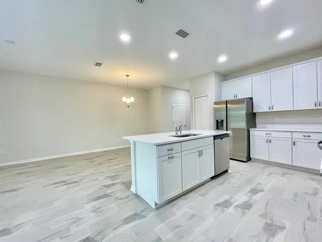 a large white kitchen with cabinets