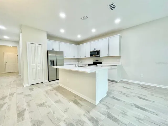 a kitchen with stainless steel appliances a refrigerator sink and microwave