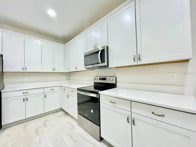 a kitchen with white cabinets stainless steel appliances and sink