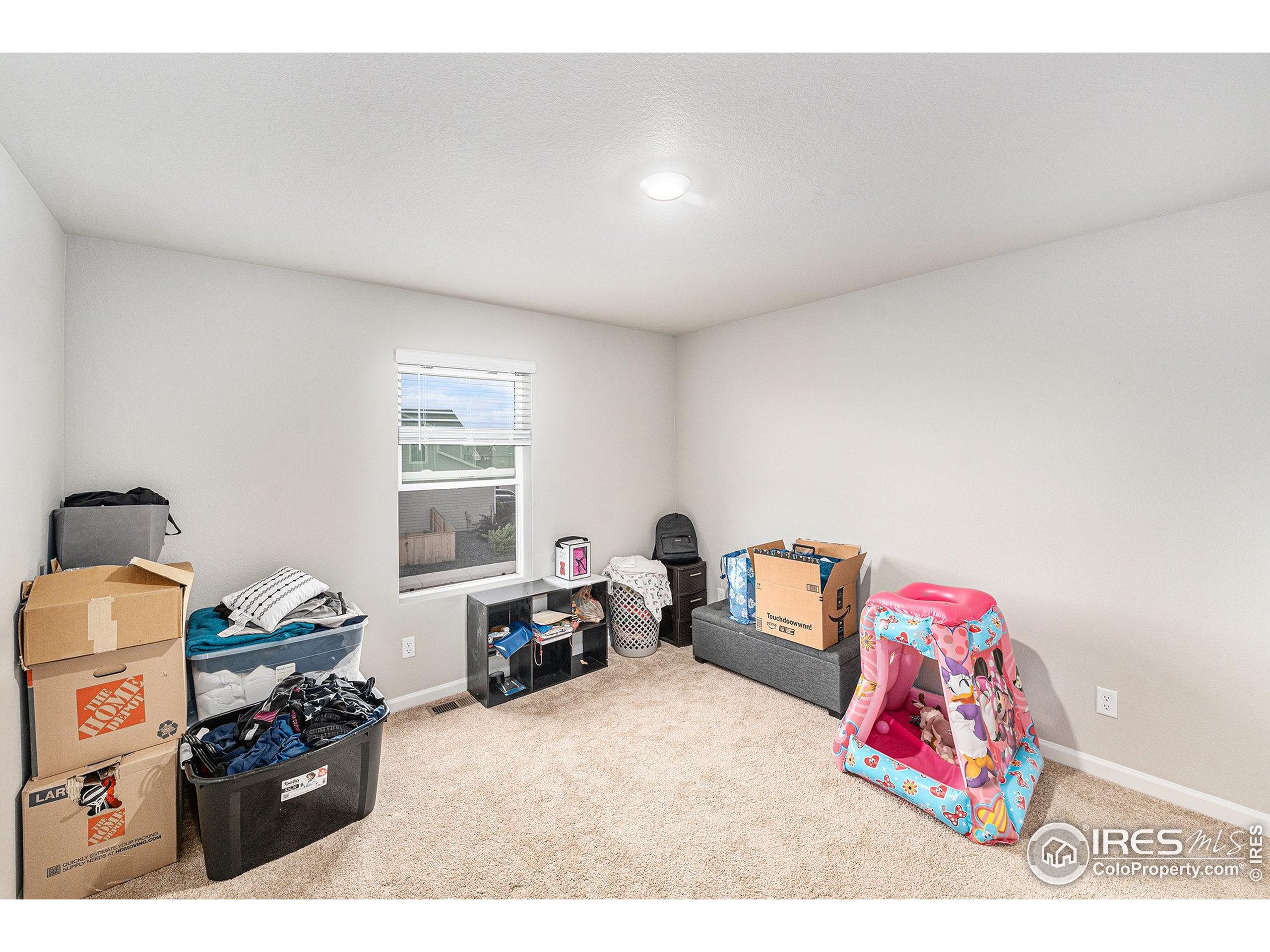 971 Ouzel Falls Road Severance, CO 80550 - Photo 14 of 16 a bedroom with a bed and a couch