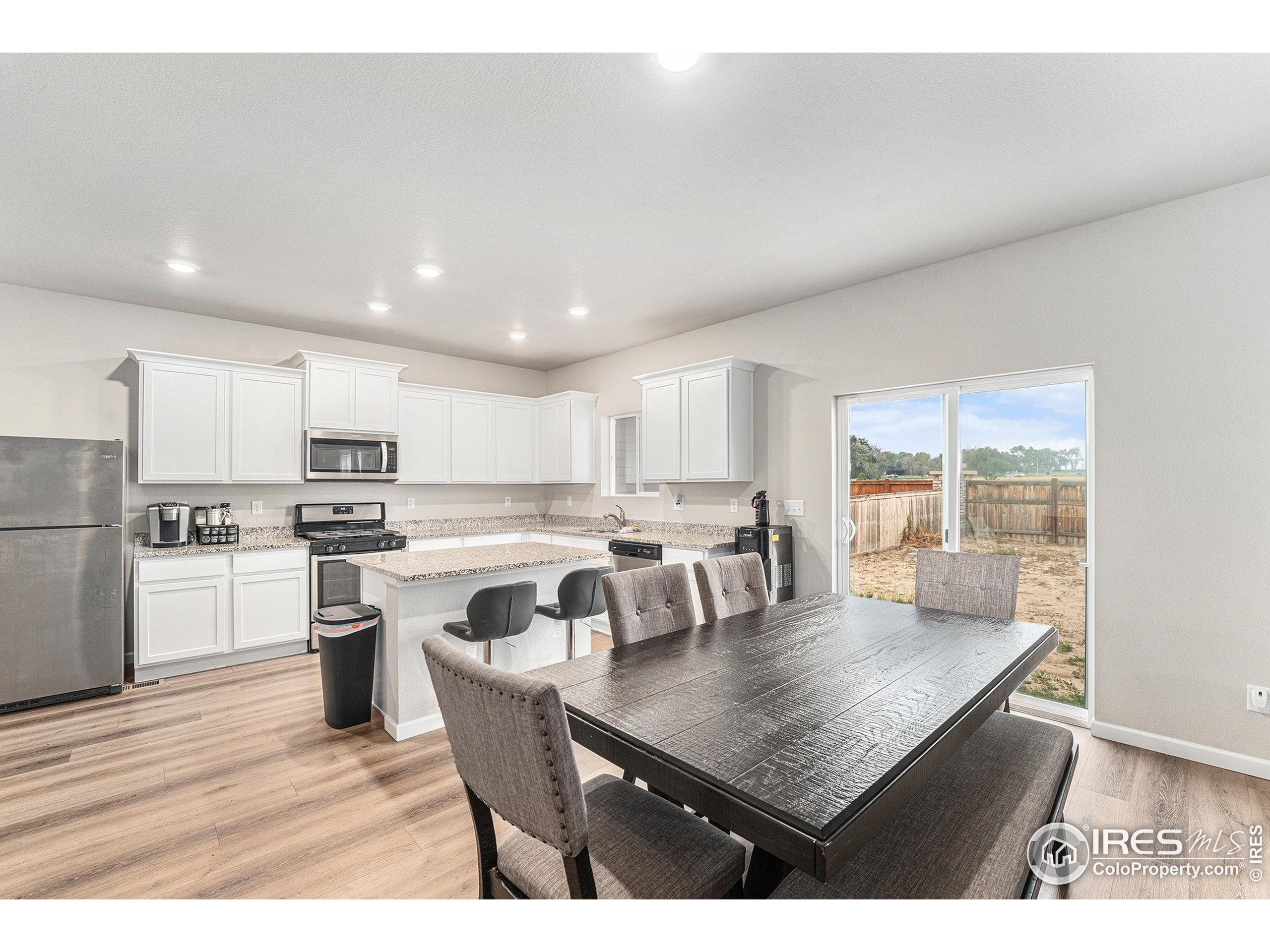 971 Ouzel Falls Road Severance, CO 80550 - Photo 6 of 16 a kitchen with a dining table chairs and wooden floor