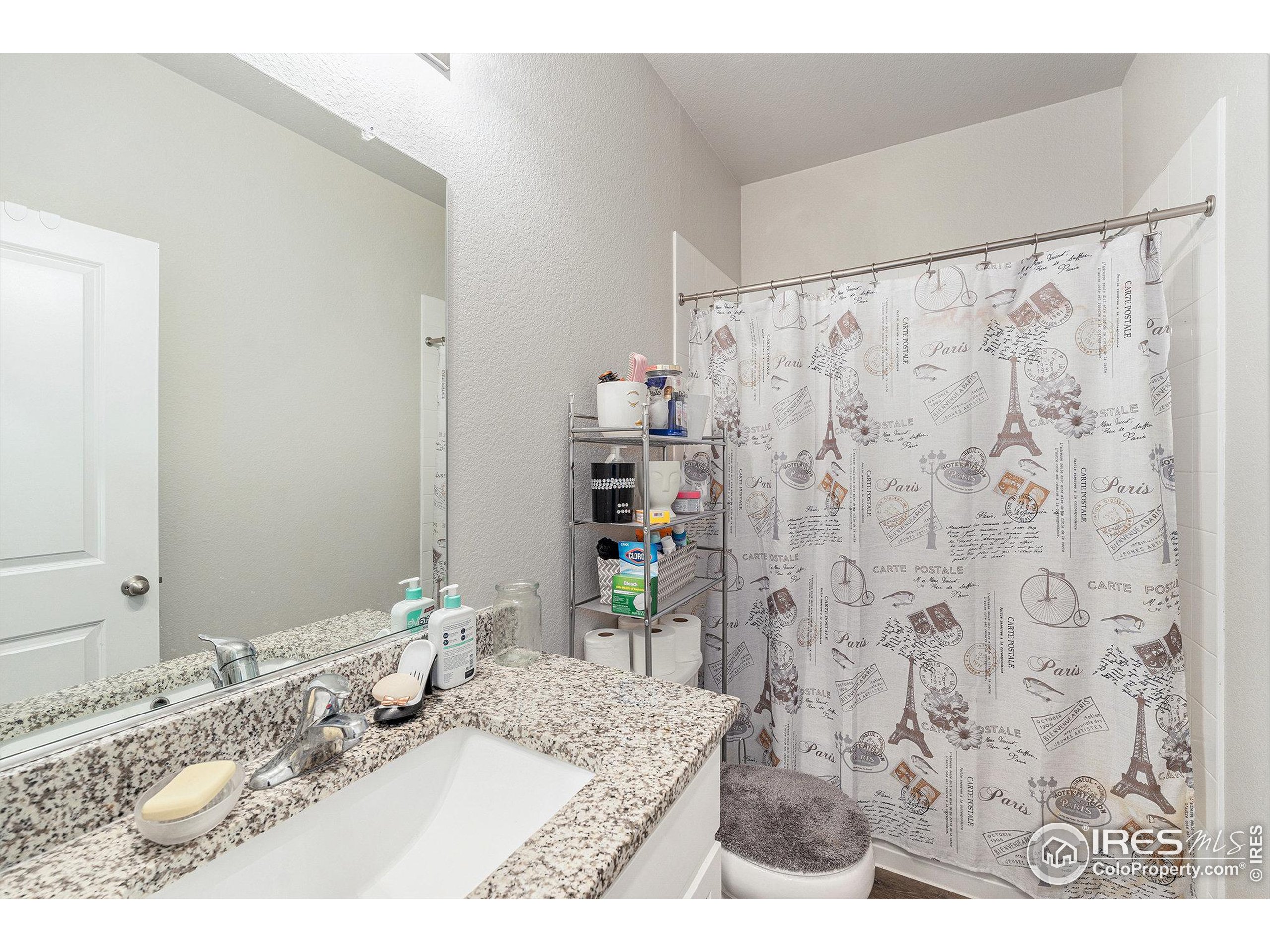 971 Ouzel Falls Road Severance, CO 80550 - Photo 7 of 16 a bathroom with a granite countertop sink a mirror and shower