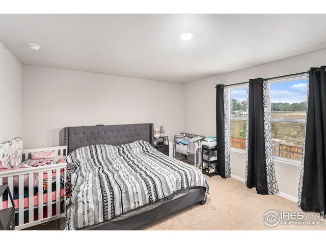 a bed sitting in a bedroom next to a window