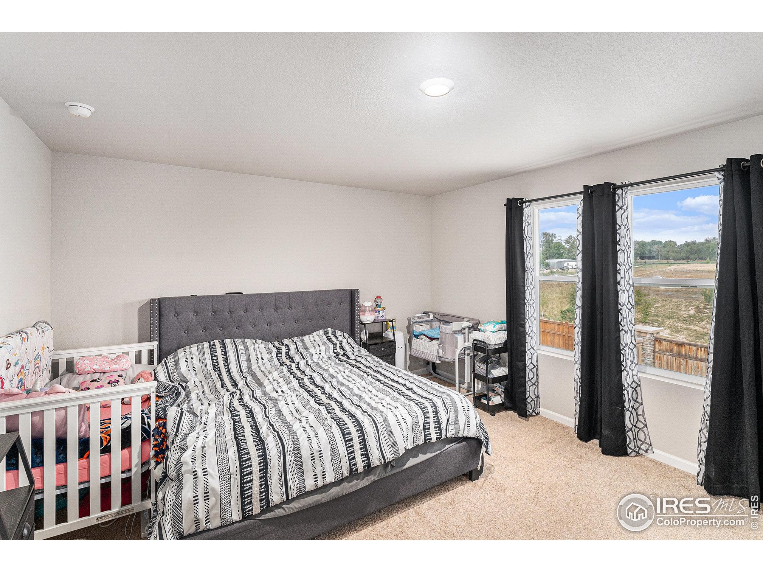 971 Ouzel Falls Road Severance, CO 80550 - Photo 8 of 16 a bed sitting in a bedroom next to a window