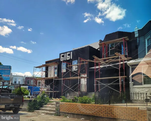 a front view of a house with plants