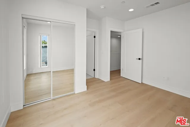 an empty room with closet and wooden floor