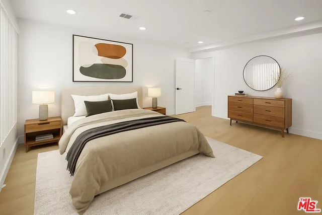 a bedroom with a bed and wooden floor