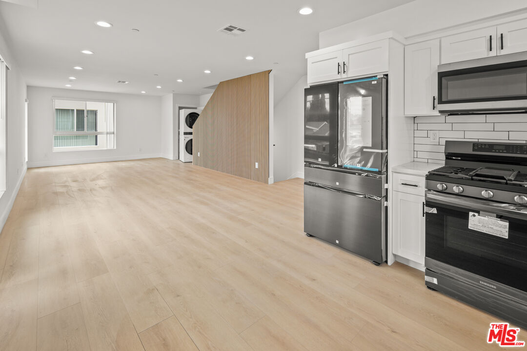 2700 Fletcher Drive, Unit A Los Angeles, CA 90039 - Photo 9 of 33 a kitchen with stainless steel appliances kitchen island granite countertop a stove a refrigerator and a microwave oven with large wooden cabinets