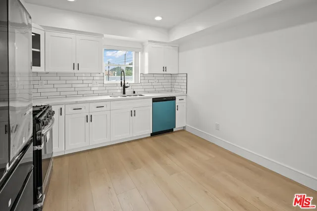 a kitchen with granite countertop white cabinets and white appliances