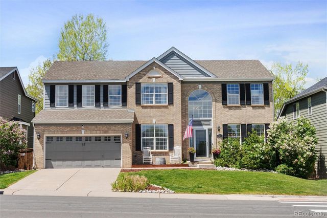 a front view of a house with a garden and garage
