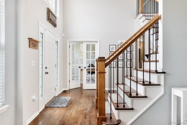 a view of staircase with lots of frames on wall and wooden floor