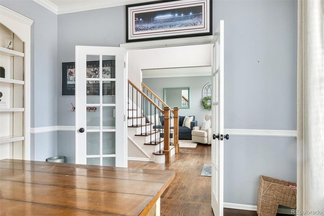 a view of a hallway to a livingroom with wooden floor and furniture