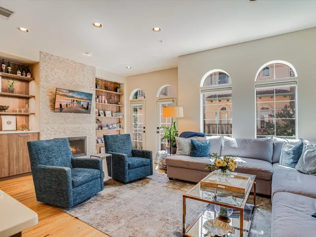 a living room with fireplace furniture and a large window