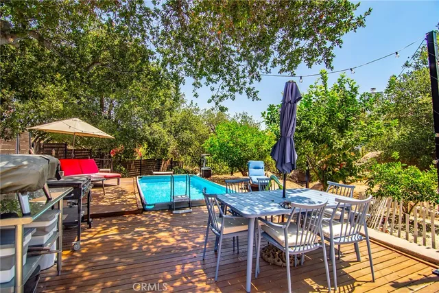 a view of a backyard with potted plants and large trees