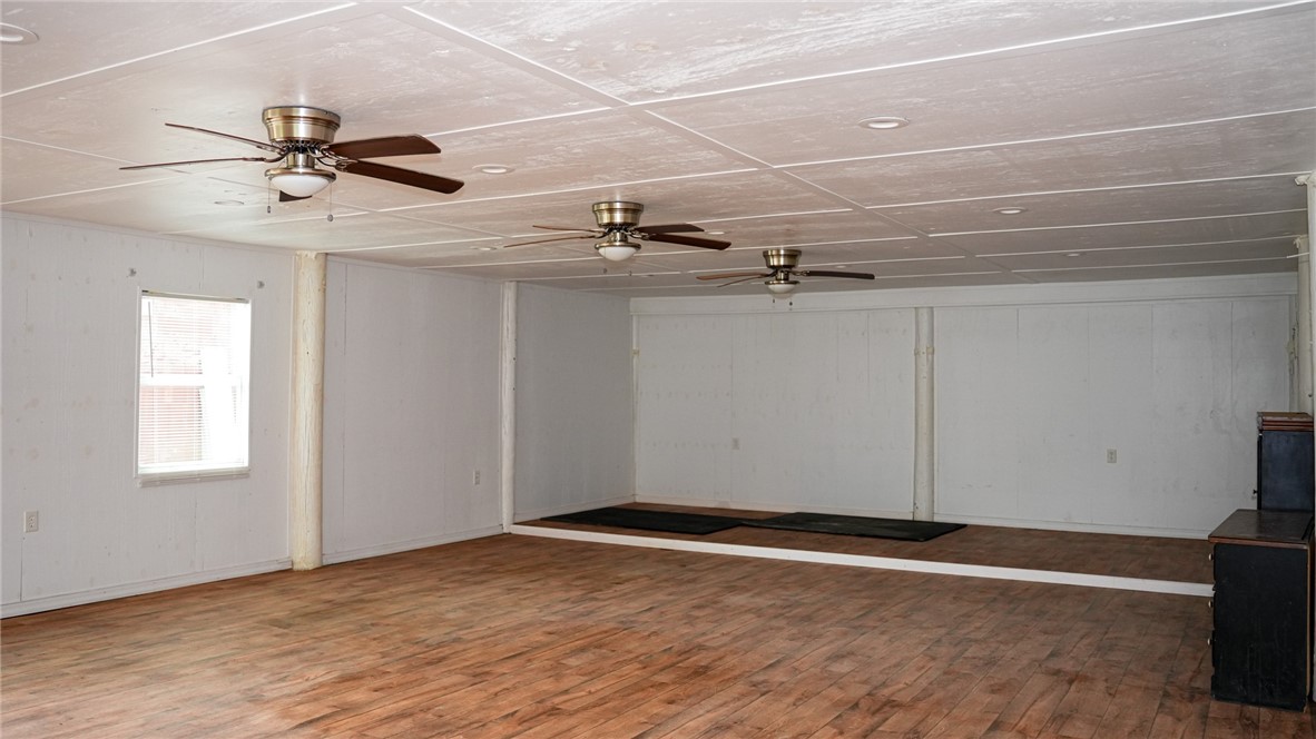 4761 Jorgensen Road Fort Pierce, FL 34981 - Photo 17 of 26 an empty room with wooden floor a ceiling fan and windows