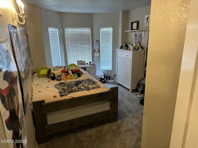 a bed sitting in a bedroom next to a window