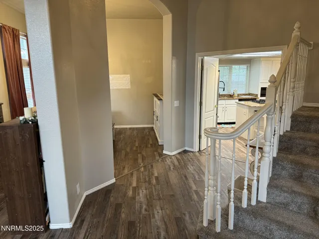 a view of a hallway with wooden floor and staircase