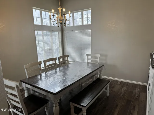 a room with a table chairs and chandelier