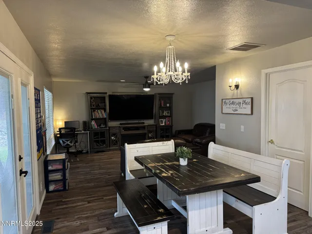 a living room with furniture a chandelier and a flat screen tv