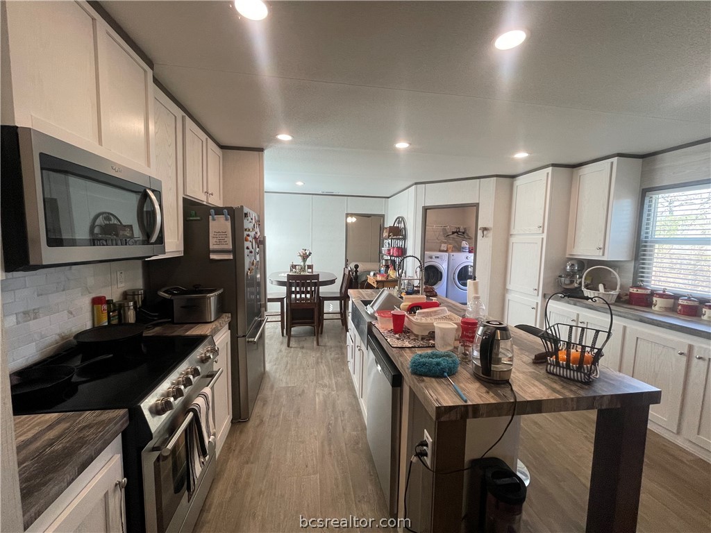 11320 Old Hearne Road Bryan, TX 77807 - Photo 4 of 26 a kitchen that has a lot of cabinets a sink and appliances