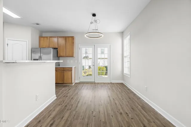 a view of a kitchen with wooden floor and electronic appliances