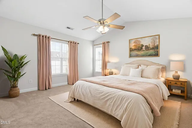 a spacious bedroom with a large bed and a chandelier
