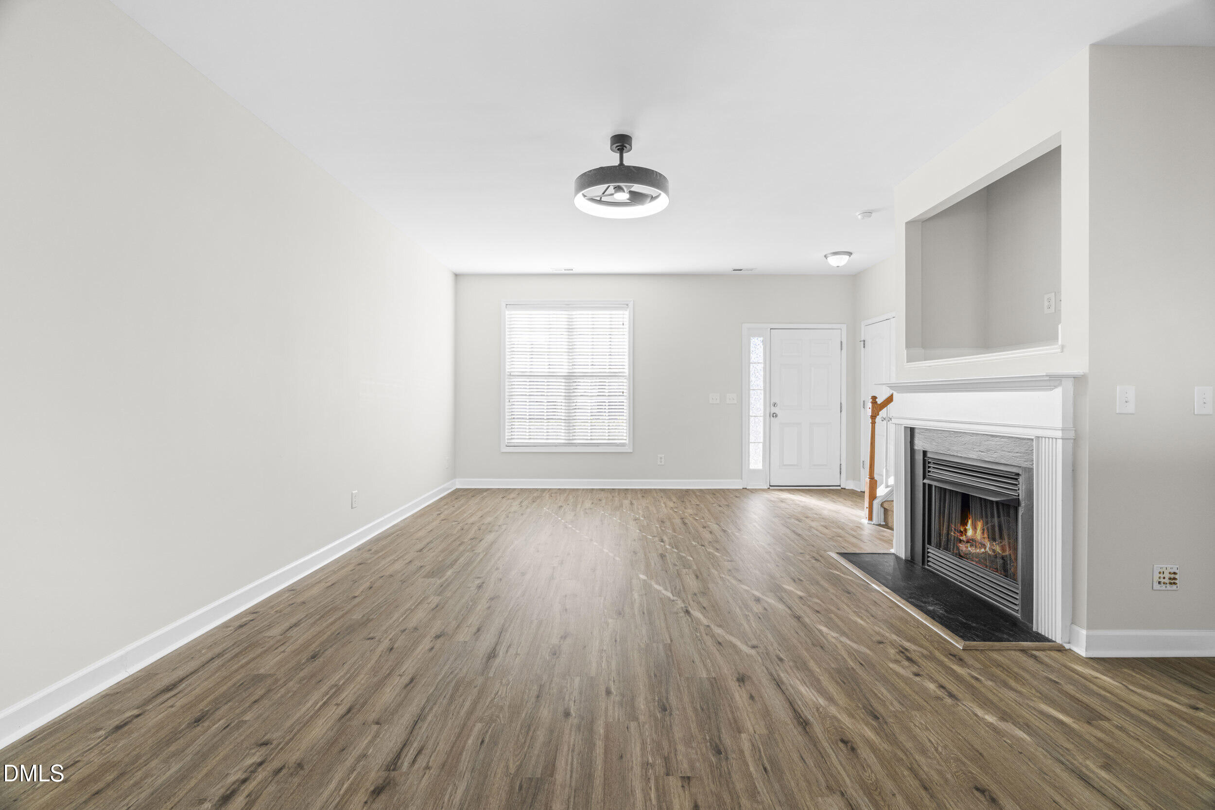 8320 Boca Point Raleigh, NC 27616 - Photo 10 of 28 a view of an empty room with wooden floor fireplace and a window