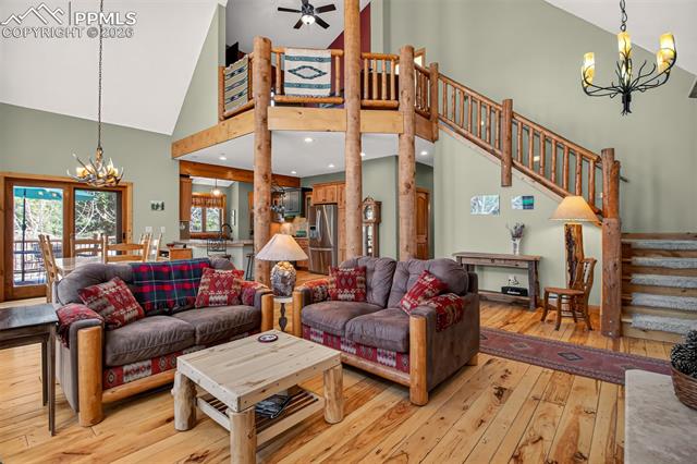 255 Summit Road Manitou Springs, CO 80829 - Photo 6 of 48 Open concept great room with vaulted ceilings, a walk out to wrap around deck, a wall of windows for plenty of natural light, knotty pecan flooring and a river rock gas fireplace
