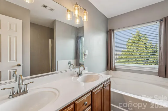 a bathroom with double vanity sink a vanity and a large mirror