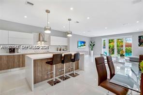 3655 Southwest 26th Street Miami, FL 33133 - Photo 3 of 15 a view of kitchen with stainless steel appliances granite countertop sink stove dining table and chairs