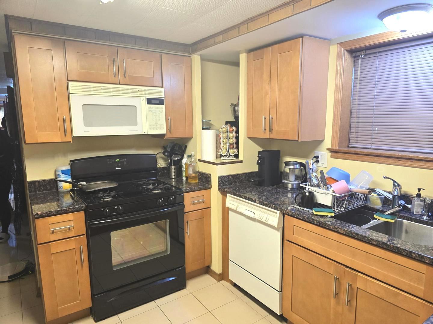 6614 West Devon Avenue Chicago, IL 60631 - Photo 14 of 21 a kitchen with granite countertop a stove a sink and a cabinets