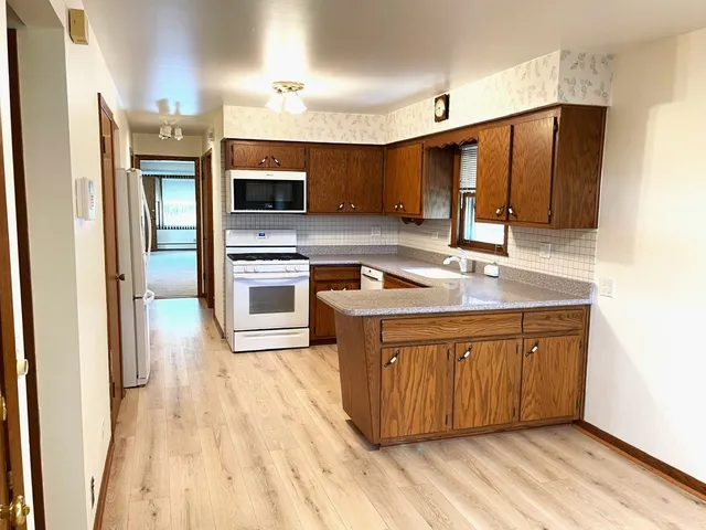 a kitchen with stainless steel appliances granite countertop a sink a stove and a refrigerator