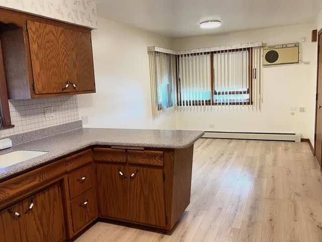 a kitchen with wooden cabinets and a wooden floor