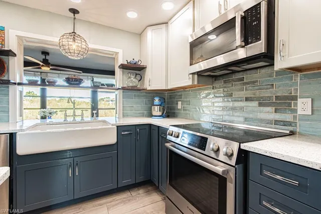 a kitchen with stainless steel appliances granite countertop a sink a stove and microwave