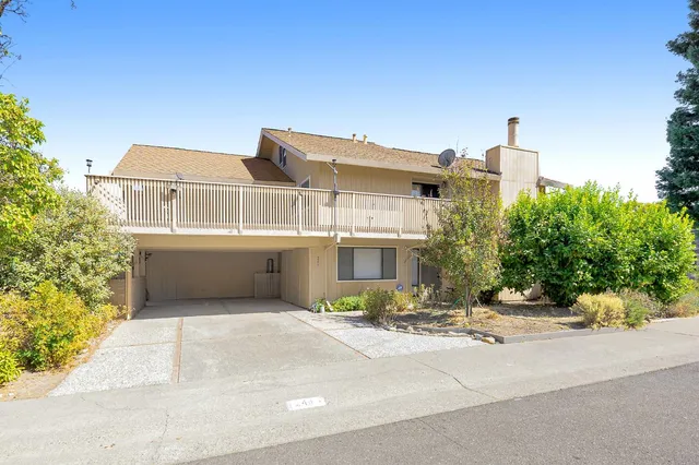 a view of an empty room with wooden floor and fan
