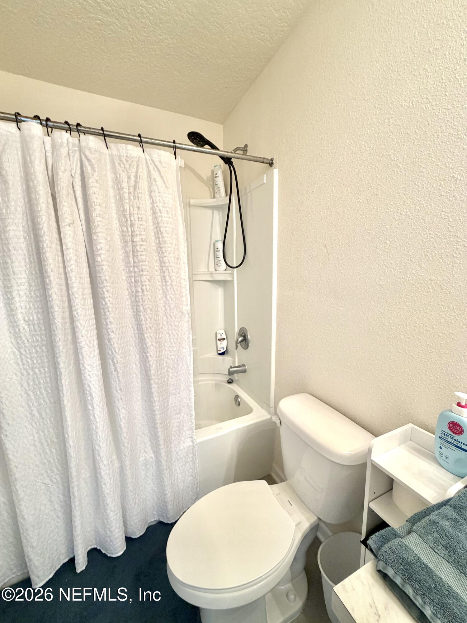 845 Observatory Parkway Jacksonville, FL 32218 - Photo 22 of 42 a white toilet sitting next to a shower curtain