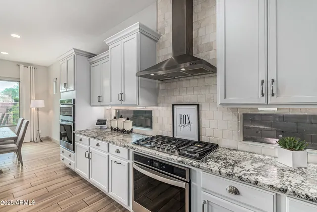 a kitchen with stainless steel appliances granite countertop a stove and a white cabinets