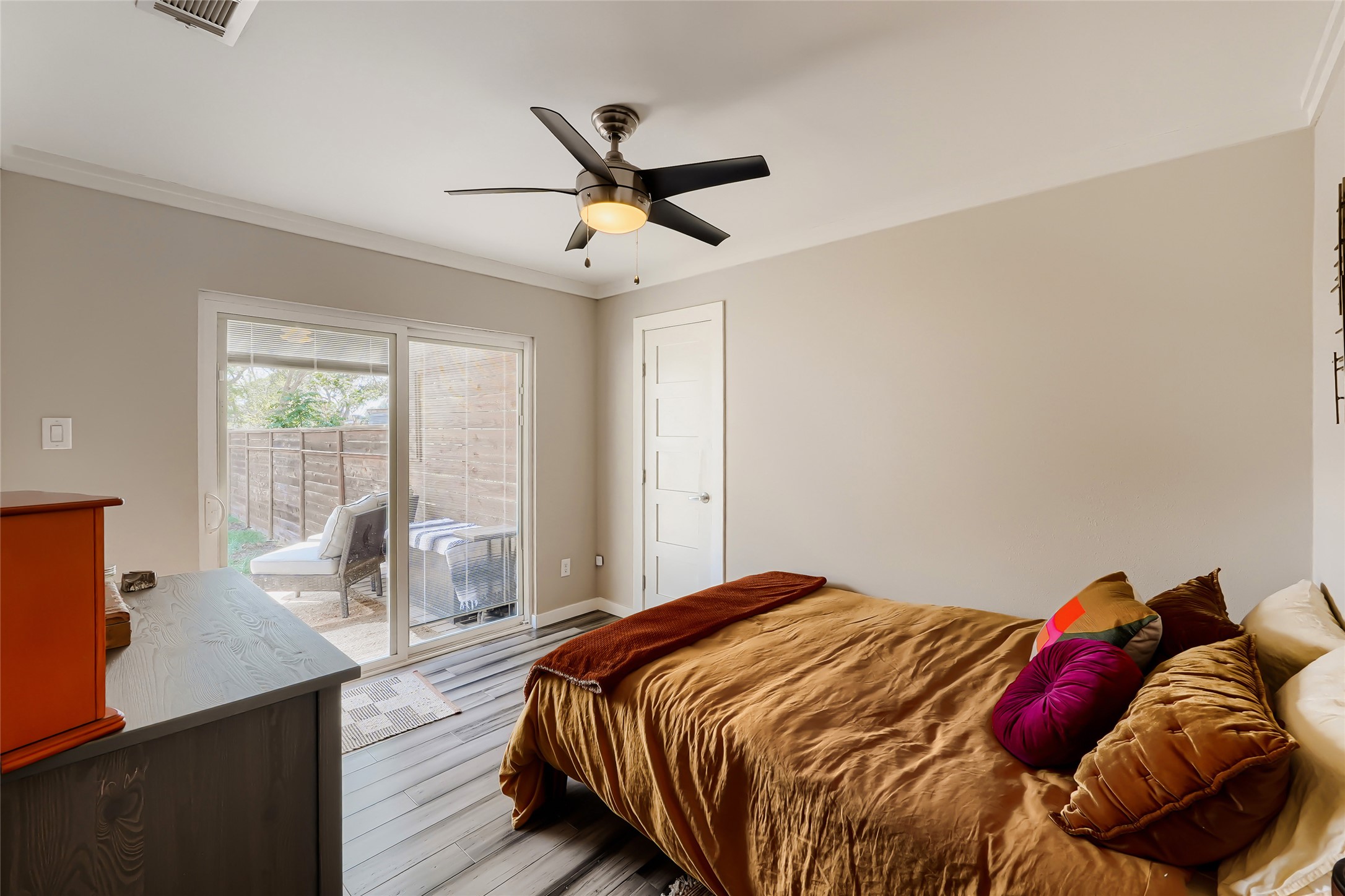 5707 Tracy Lynn Lane, Unit A Austin, TX 78721 - Photo 20 of 33 Bedroom featuring access to exterior, ornamental molding, light wood finished floors, and ceiling fan
