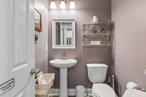 a bathroom with a toilet sink and mirror