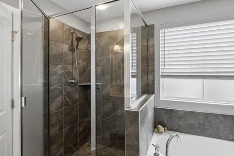 a bathroom with a granite countertop bathtub shower and sink