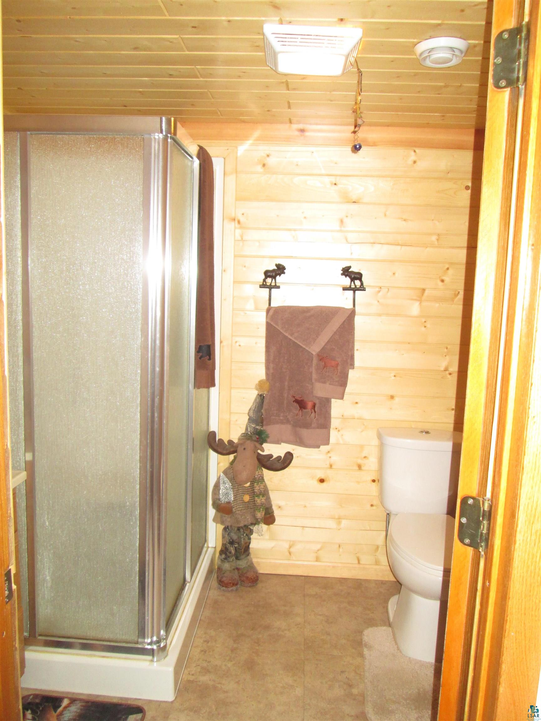 8882 Shortcut Road Lake Nebagamon, WI 54849 - Photo 24 of 47 Full bathroom featuring wooden ceiling, toilet, a shower stall, and wooden walls