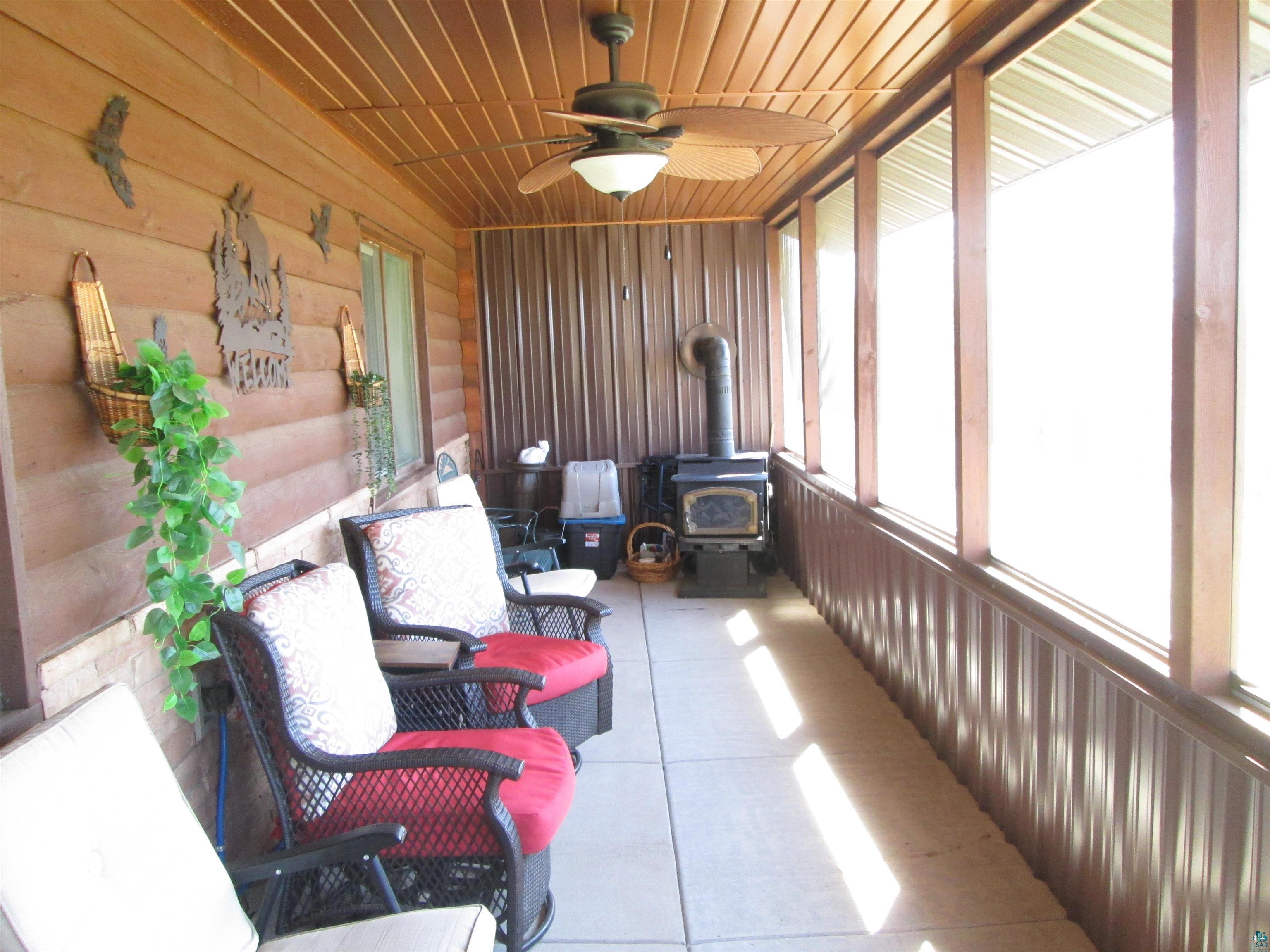 8882 Shortcut Road Lake Nebagamon, WI 54849 - Photo 5 of 47 Sunroom with a ceiling fan and a wood stove