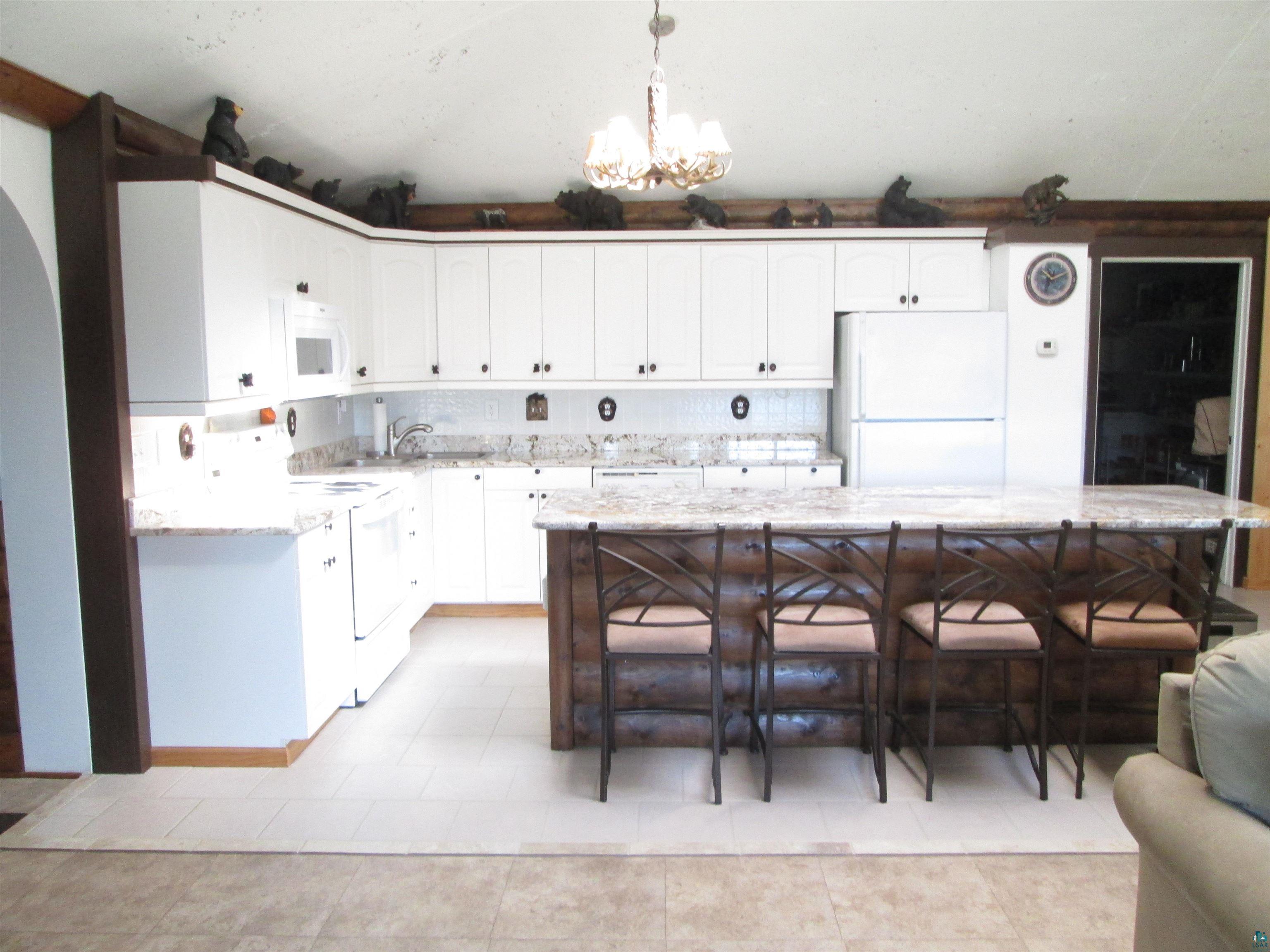 8882 Shortcut Road Lake Nebagamon, WI 54849 - Photo 10 of 47 Kitchen with hanging light fixtures, a sink, white cabinets, light stone countertops, and white appliances