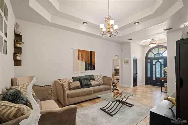 a living room with furniture a dining table and a chandelier