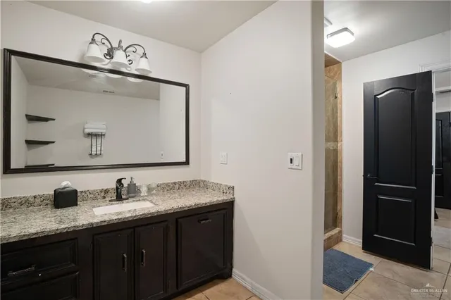 a bathroom with a granite countertop sink and a mirror
