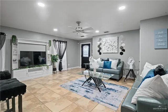 a living room with furniture a flat screen tv and a table