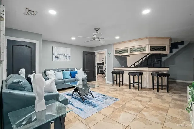 a living room with furniture a table and kitchen view