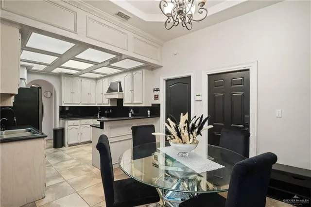 a kitchen with stainless steel appliances granite countertop a refrigerator dining table and chairs