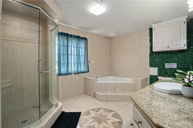 a bathroom with a granite countertop bathtub sink vanity mirror and toilet