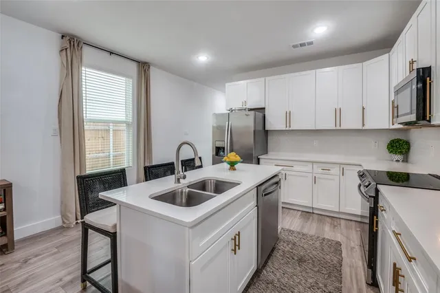 a kitchen with a stove a sink and a microwave